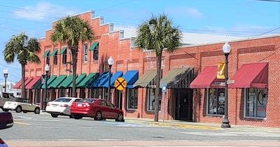 Red Brick Building with Multiple Business Green Blue and Red Awning